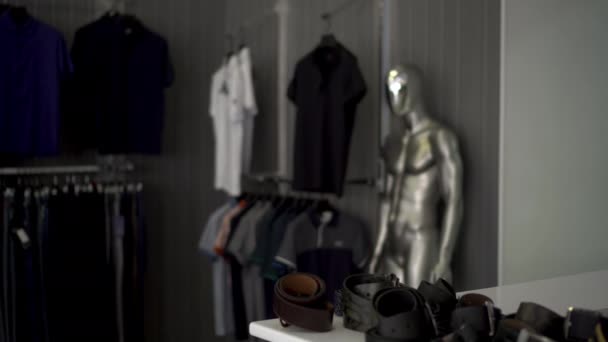 Um homem de capuz e óculos rouba um cinto de uma loja. Loja de roupas. — Vídeo de Stock