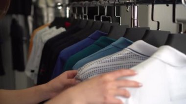 Genç bir kadın bir mağazadan gömlek seçiyordu. Giysi mağazası.