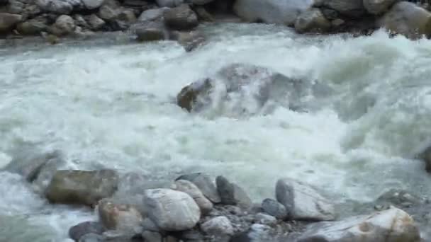 View of a fast flowing mountain river close seup. Камера следит за движением воды. — стоковое видео
