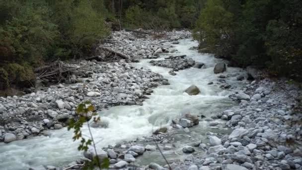 Вид на быстротекущую горную реку. Камера следит за движением воды. — стоковое видео