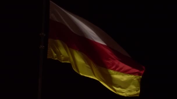 Severní Osetia vlajka ve tmě, dolní pohled detailní up. — Stock video