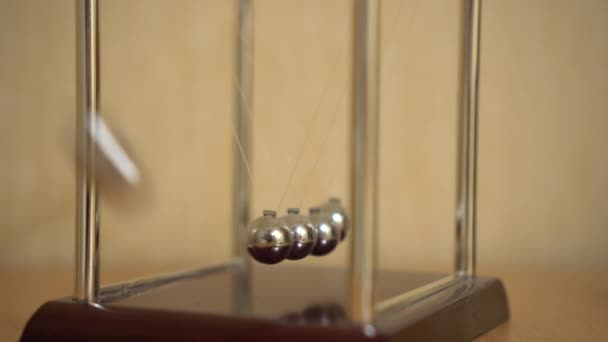 Newtons bureau wieg op tafel beweegt. Ballen verslagen door traagheid — Stockvideo