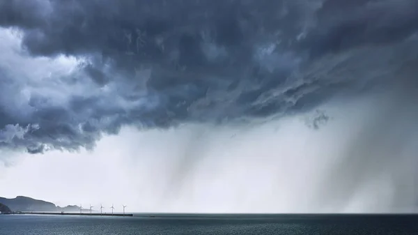 Stormy clouds with rain on the sea — Stock Photo, Image