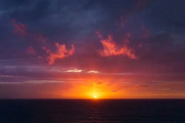 Όμορφο κόκκινο σούρουπο πάνω από τη θάλασσα με ακτίνες ηλίου — Φωτογραφία Αρχείου