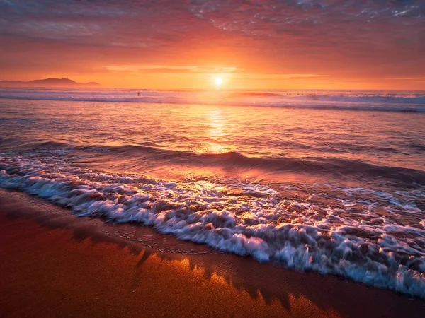 美丽的红色日落在海滩上与海浪在岸上 — 图库照片