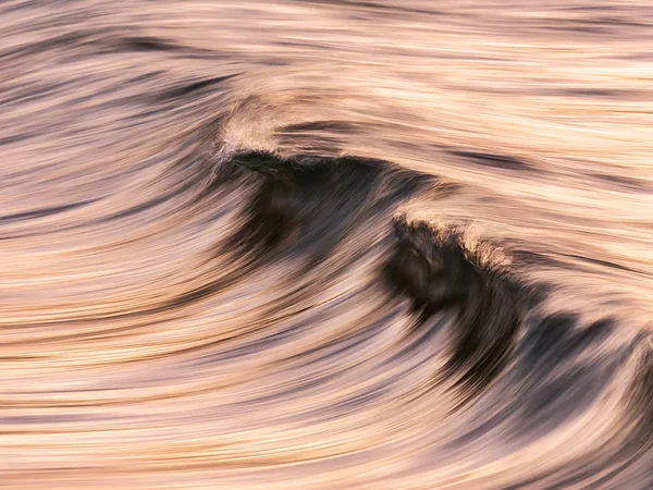 Smooth wave in motion with panning effect at sunset — Stock Photo, Image