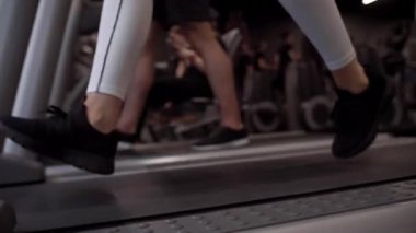 Kadın ve spor salonunda koşu bandı üzerinde çalışan adam