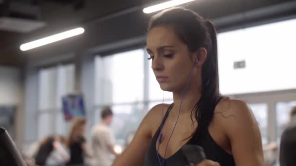 在健身房锻炼耳机的妇女 — 图库视频影像