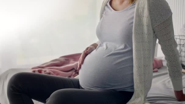 寝室のベッドの上に座って妊娠中の女性 — ストック動画