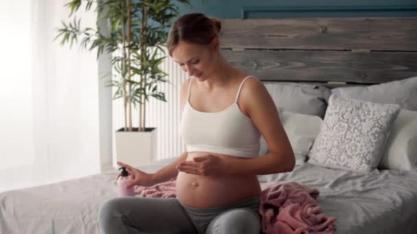 Jeune Femme Enceinte Appliquant Une Crème Hydratante Sur Son Ventre — Video