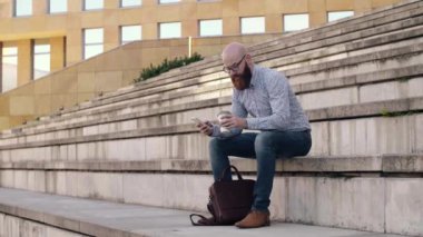Kahve içme ve açık havada cep telefonuyla işadamı