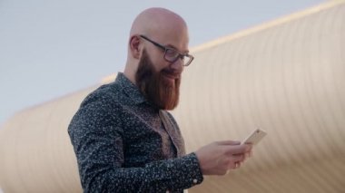 Açık havada bir akıllı telefon kullanılarak hipster işadamı