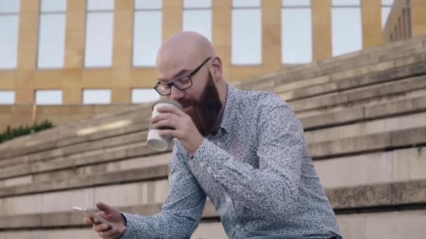 Man Dricka Kaffe Och Använder Mobiltelefon Utomhus — Stockvideo