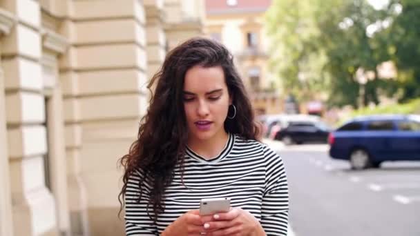Κορίτσι Χρησιμοποιώντας Ένα Κινητό Τηλέφωνο Στο Δρόμο — Αρχείο Βίντεο