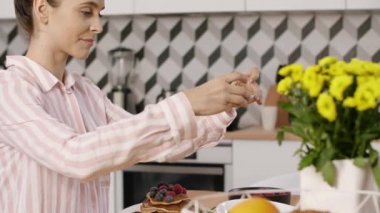 Krep meyve ile mutfakta kahvaltı sırasında fotoğraf çekimi kadın