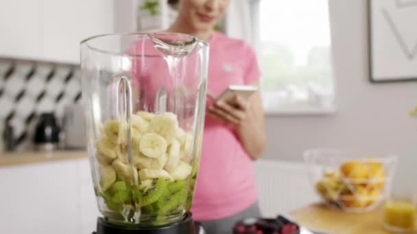 Mujer Joven Usando Teléfono Móvil Preparando Desayuno Cocina — Vídeos de Stock