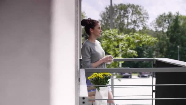 在阳台上喝咖啡或喝茶的年轻女子 — 图库视频影像