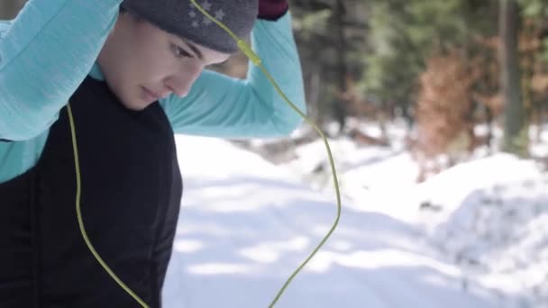 妇女与耳机慢跑在冬天天 — 图库视频影像