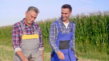 Mısır tarlada yürümek iki neşeli çiftçiler