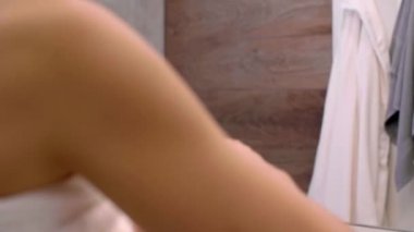 Tuvalette yüz kremi süren bir kadın.