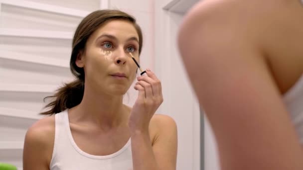 Femme Appliquant Correcteur Sur Son Visage Dans Salle Bain — Video