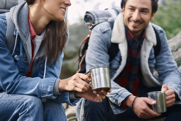 Two backpackers drinking coffee and talking