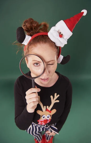 虫眼鏡を通して見るクリスマスの服の女性 — ストック写真