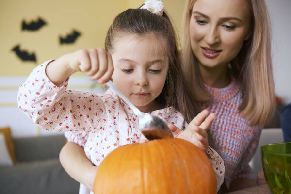 Мать и дочь работают над тыквами на Хэллоуин 