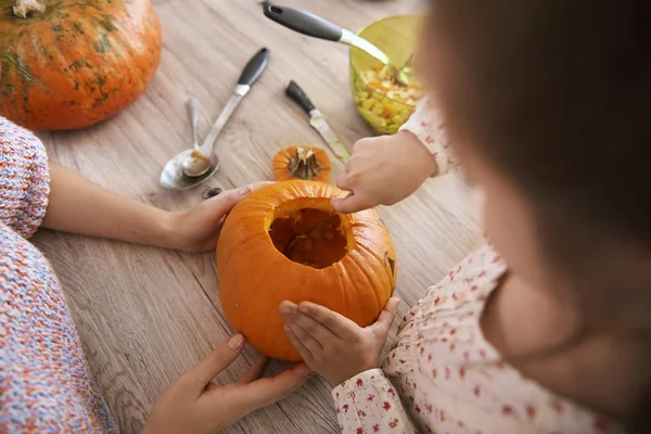 Parent helping child in making decorations for Halloween