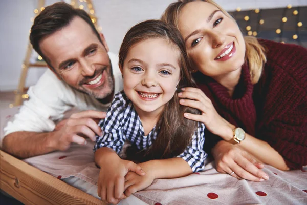 クリスマスの時にベッドで横になっている家族の肖像 — ストック写真