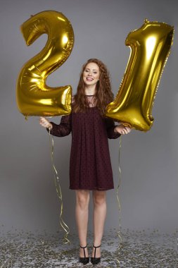 Mutlu genç kadın altın balonlu Doğum günü kutluyor