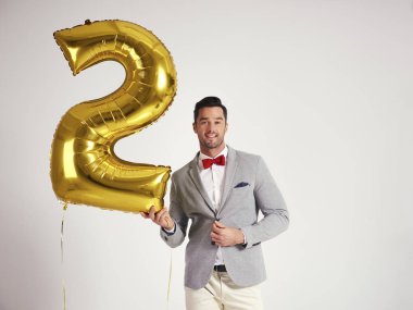 Young man with golden balloon celebrating second birthday his company clipart
