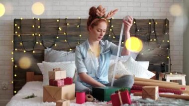 Mutlu kız yatakta Noel hediyeleri kaydırma
