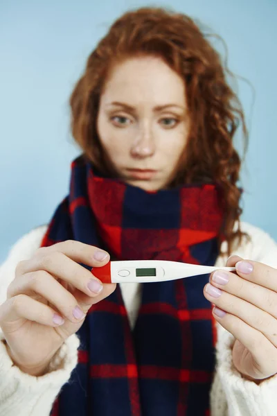 Woman's hands holding digital thermometer