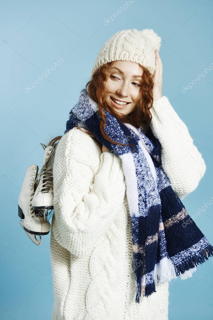 Side view of smiling girl holding ice skates