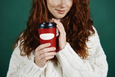 Close up of girl holding disposable mug of coffee  clipart