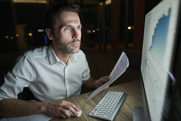 Homem Focado Com Documento Usando Computador — Fotografia de Stock