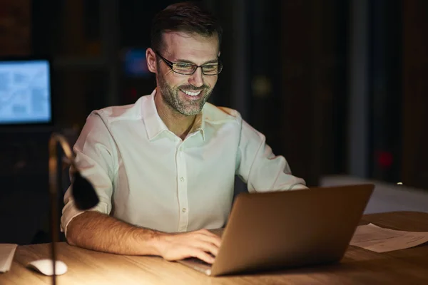 Χαμογελαστός Άνθρωπος Χρησιμοποιώντας Ένα Φορητό Υπολογιστή Νύχτα — Φωτογραφία Αρχείου