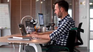 Ofiste dizüstü bilgisayar kullanan adam yan görünüm