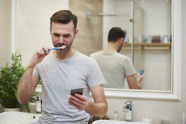 Homem Escovando Dentes Usando Telefone Celular Banheiro — Fotografia de Stock