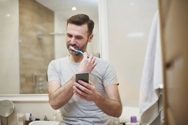 Homem Escovando Dentes Usando Telefone Celular — Fotografia de Stock