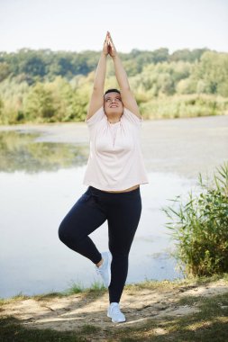 Doğa ile çevrili yoga yaparken genç kadın