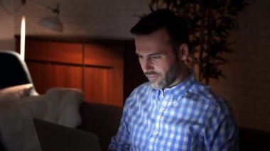 Geceleri bir dizüstü bilgisayar kullanan oynak adam