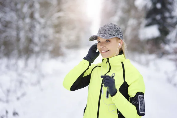 Lachende Vrouw Kiezen Van Het Beste Nummer Voor Hardlopen — Stockfoto