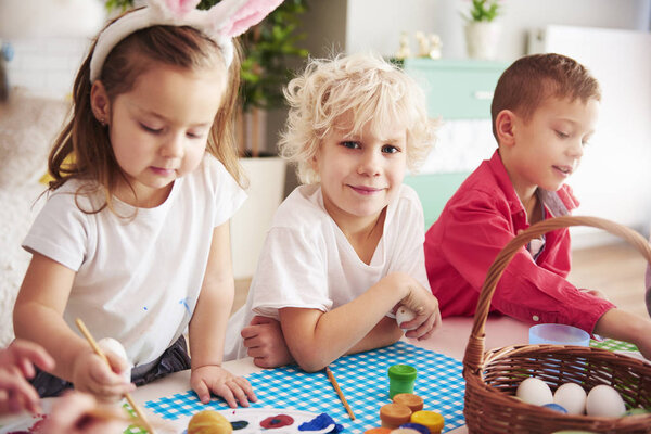 Happy kids start decorating easter eggs