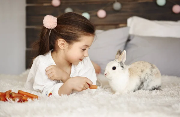 Chica Acostada Cama Alimentando Conejo —  Fotos de Stock