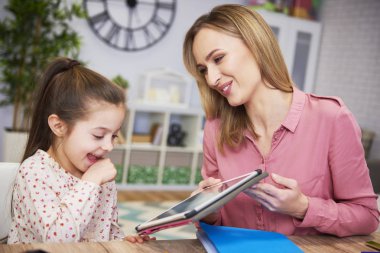 Genç anne ve kızı evde tablet kullanma 
