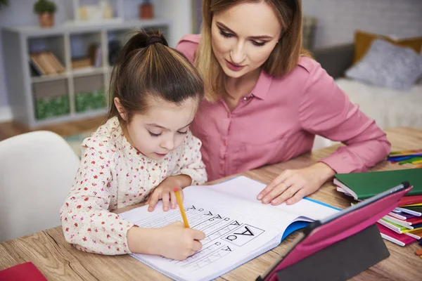 Junge Frau Hilft Mädchen Bei Den Hausaufgaben — Stockfoto