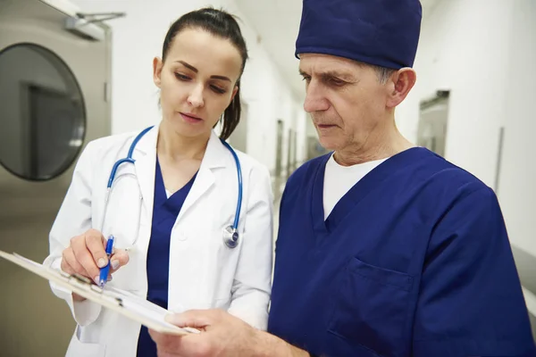 Dos Doctores Discutiendo Algunos Registros Médicos Pasillo — Foto de Stock