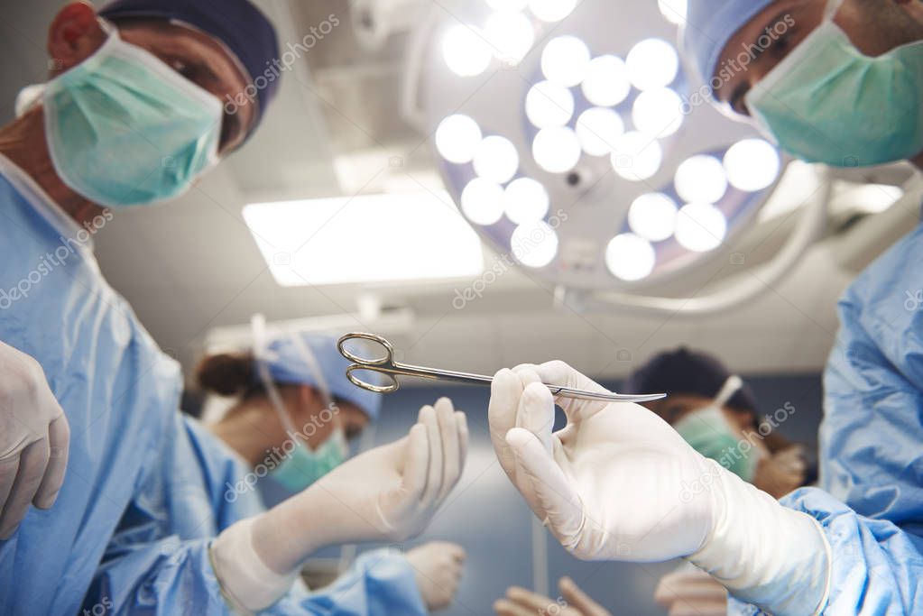 Surgeons passing scissors to each other 